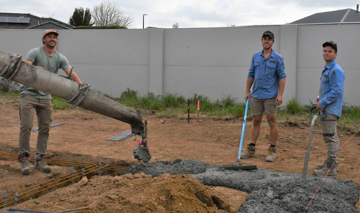 CONSTRUCTION BOOM: Lewis Reardon [middle] pouring concrete at a job in Goulburn. Photo: Hannah Neale