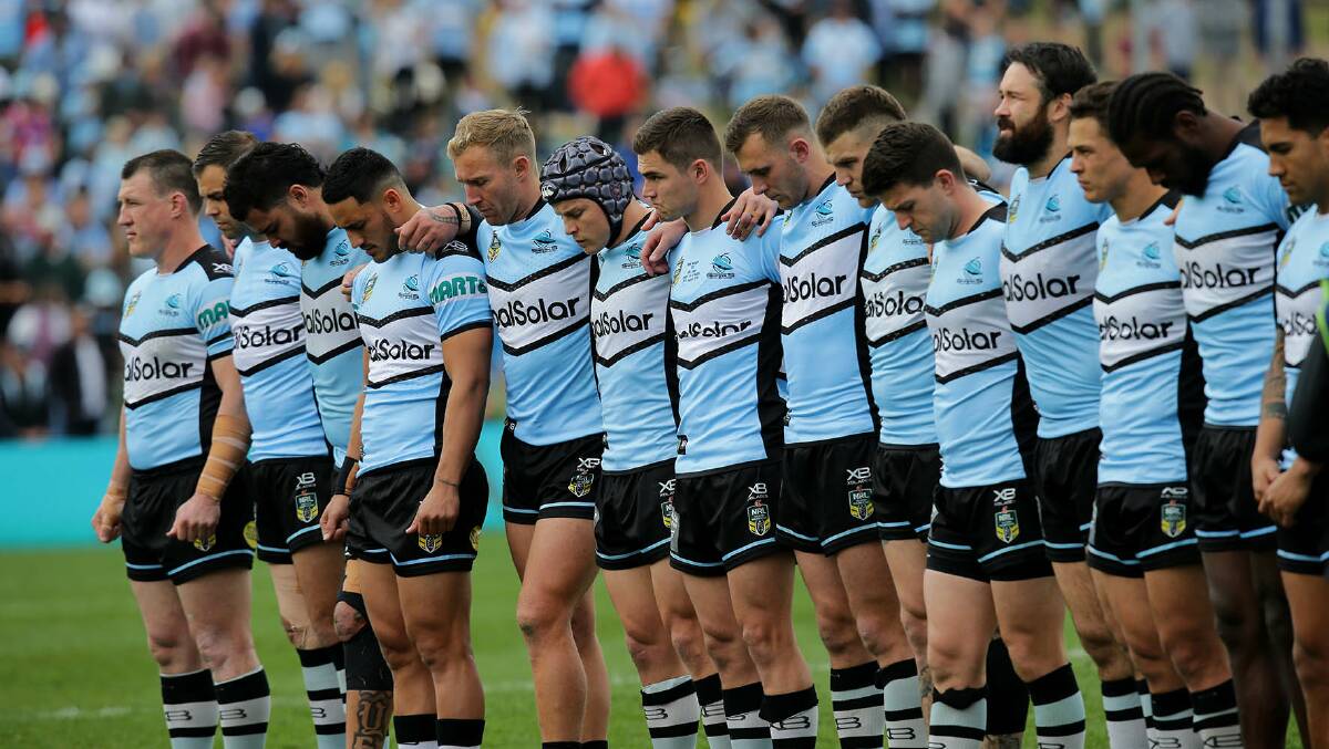 Respect: Cronulla Sharks players line up for a minute's silence before their game with Newcastle at Shark Park. Picture: John Veage