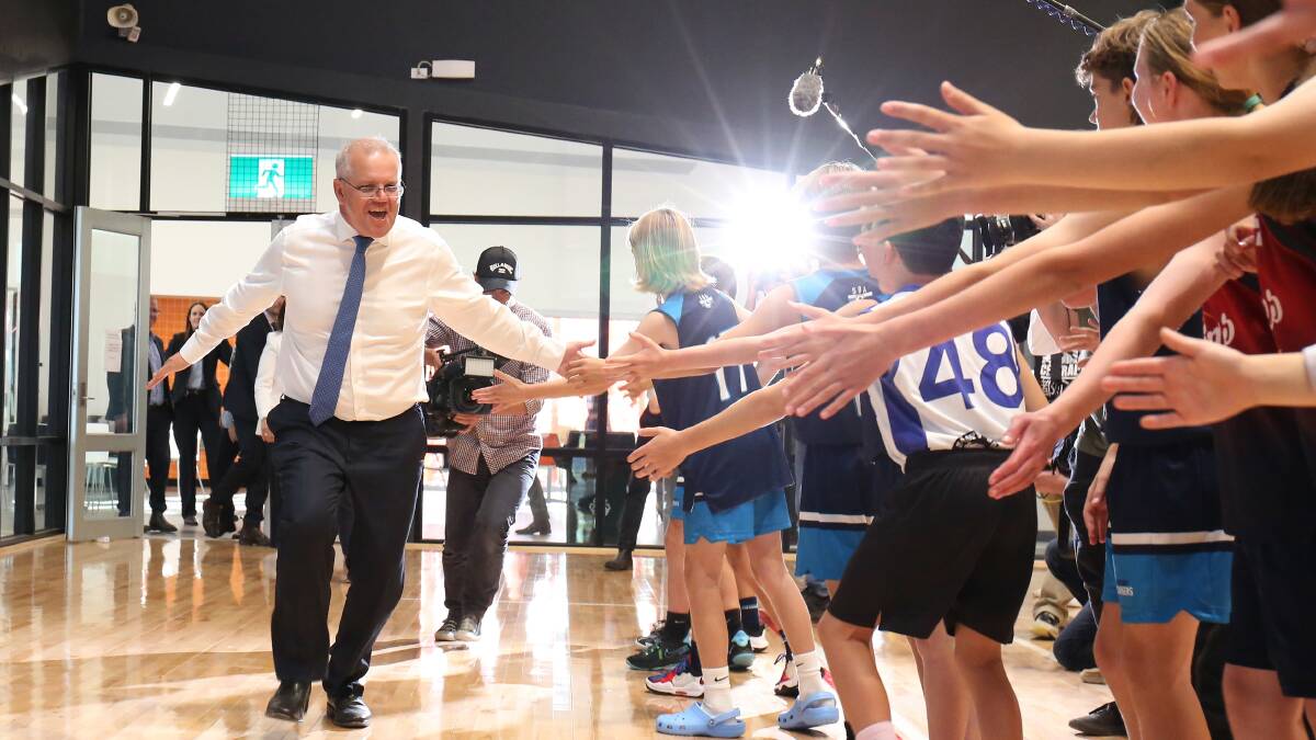 High fives: Scott Morrison on the campaign trail earlier in the year. There were no high fives during yesterday's press conference. Picture: James Croucher