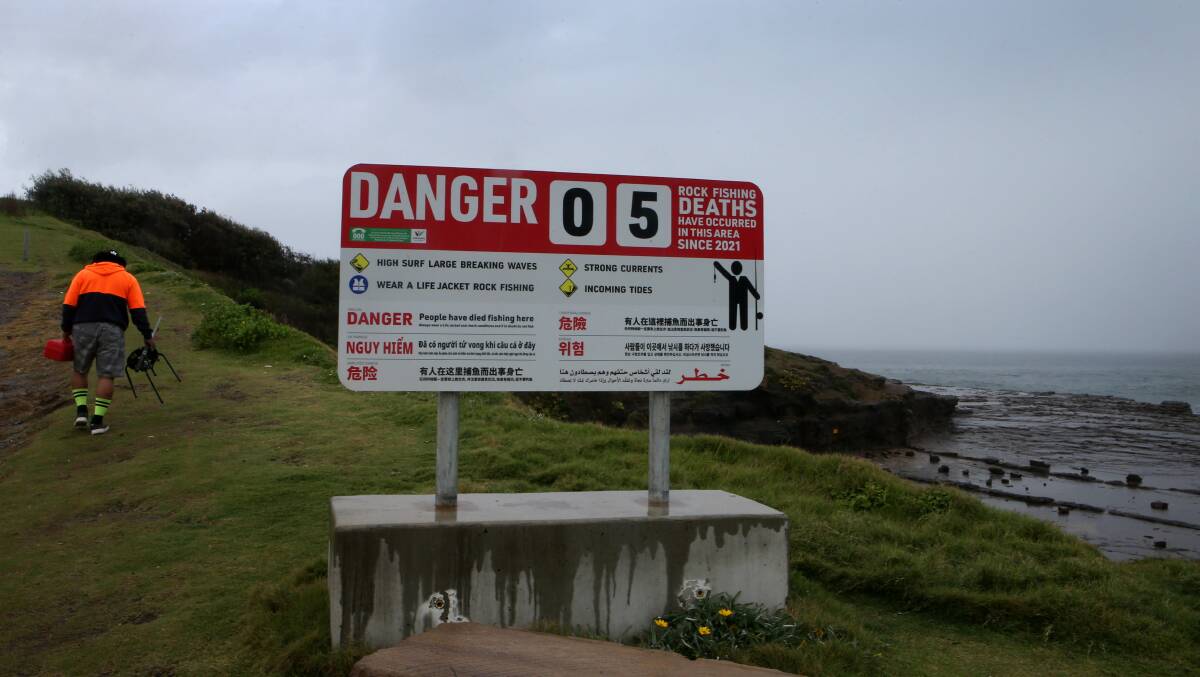 Before Brenden Buxton Hurd was swept to his death in April, the warning sign at Hill 60 in Port Kembla displays the number of rock fishing tragedies in the last year. Picture: Sylvia Liber. 