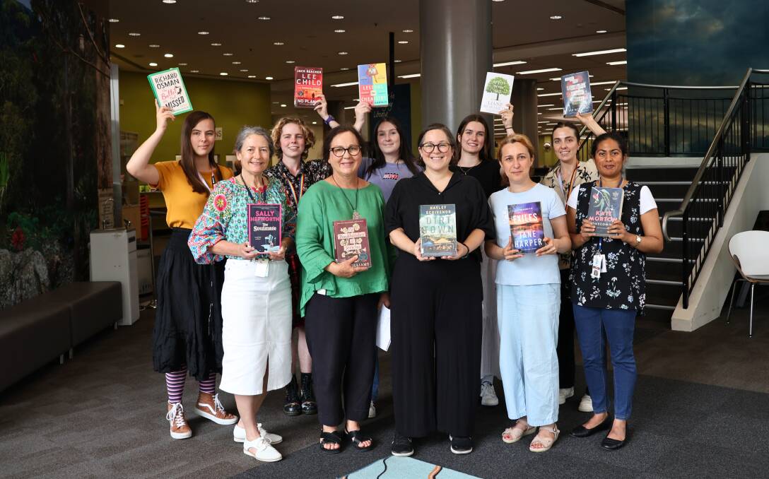 hayley Scrivenor, front and centre, with her book Dirt Town, is surrounded by staff with other books in the most borrowed top 10. Picture supplied