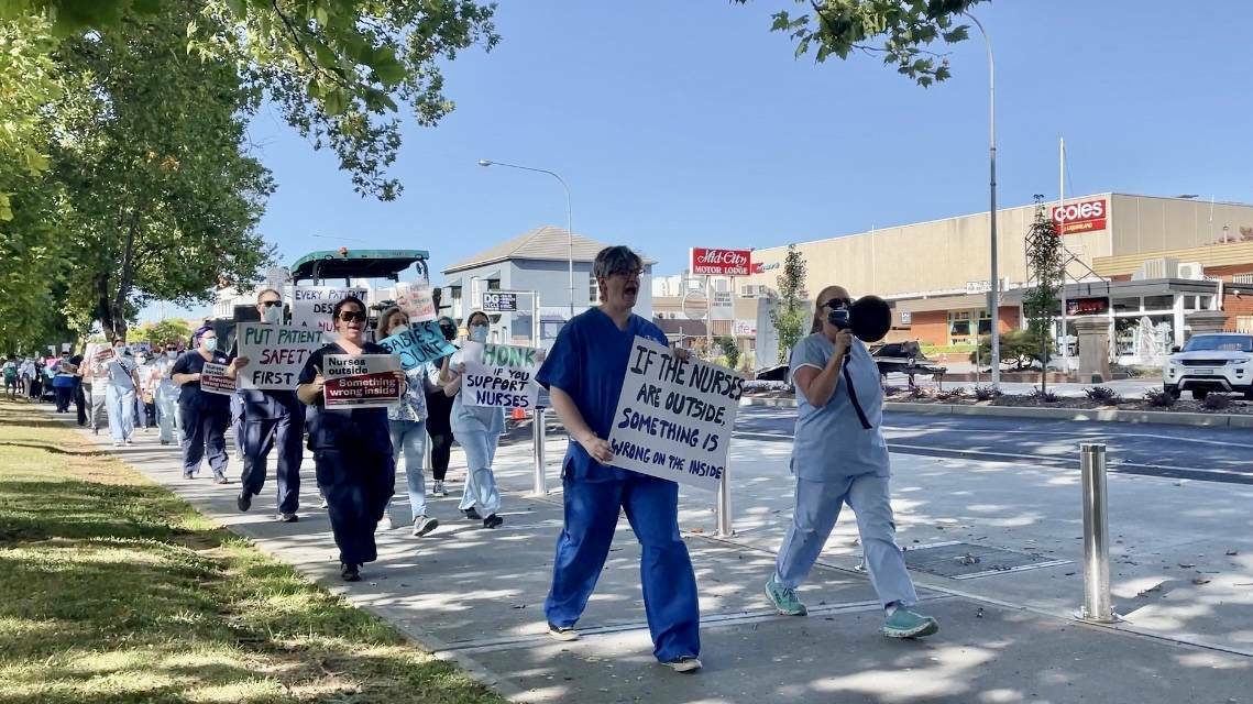  Nurses and midwives displayed signage such as 'stop telling us to cope' and 'if the nurses are outside, something is wrong on the inside'. Photo: Emily Goburg