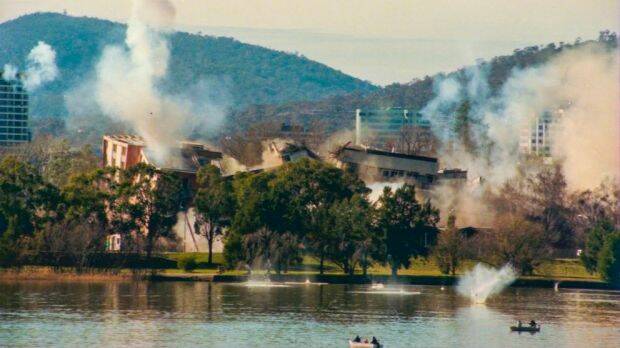 The implosion of the Royal Canberra Hospital as captured by a Canberra Times' photographer, showing debris hitting the water. Photo: Graham Tidy

