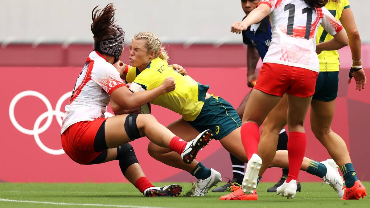 Powerful: Emma Tonegato charges over the top of a Japanese defender on the way to the try line. Picture: Dan Mullan/Getty Images