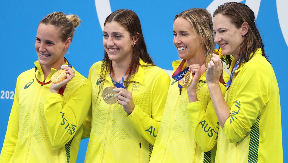 Golden glow: Emma McKeon and the Australian 4x100m freestyle team celebrate Sunday's victory. Picture: Abbie Parr/Getty Images