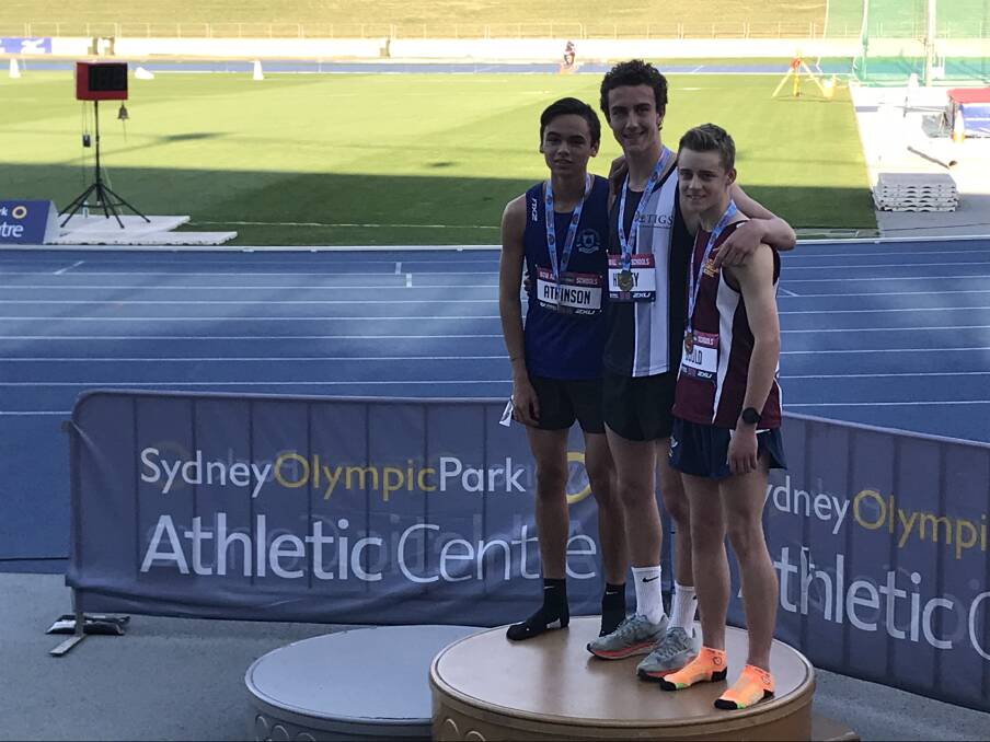 State champion: James Healey (centre) with his gold medal from the NSW All Schools Athletics Championships.
