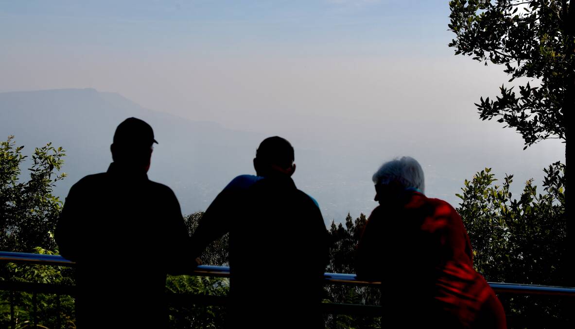 Smoky view: Tourists looking out from Mount Keira summit as smoke blankets Wollongong for another day. Dust and smoke haze are likely to be a feature of the summer, with more heat and little rain predicted. Photo:Adam McLean.