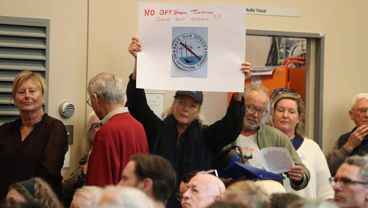 Anti wind farm campaigners held up signs and clamoured to have their say at the Thirroul community centre forum. Picture by Robert Peet