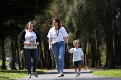 Naomi Bowden, left, with a photo of her daughter Bella who was stillborn in 2009, walks with Amanda Mayberry - who lost her daughter Eva in 2016 - and her three year old son Nate. Picture by Sylvia Liber.
