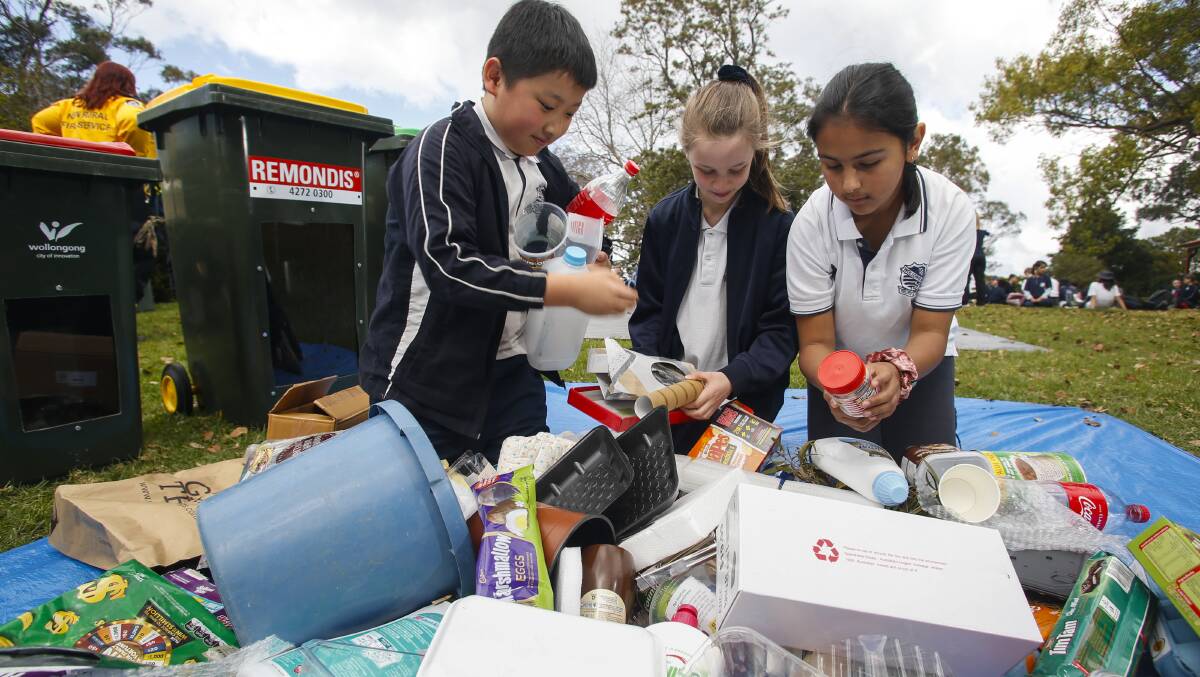 RISE AND SHINE: Jake Cheng, Tara Platup and Alara Muftuoglu, from Wollongong Public School, test their recycling knowledge. Picture: Anna Warr.