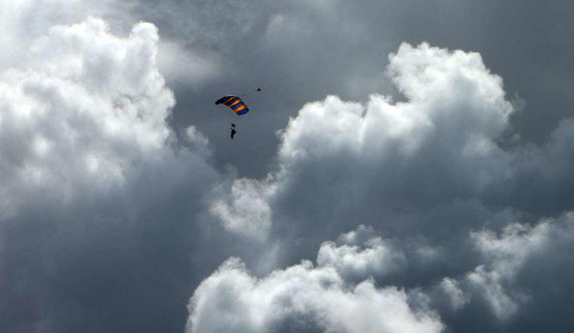 Common sight: A skydiver sails through the clouds above Wollongong. Picture: Kirk Gilmour.