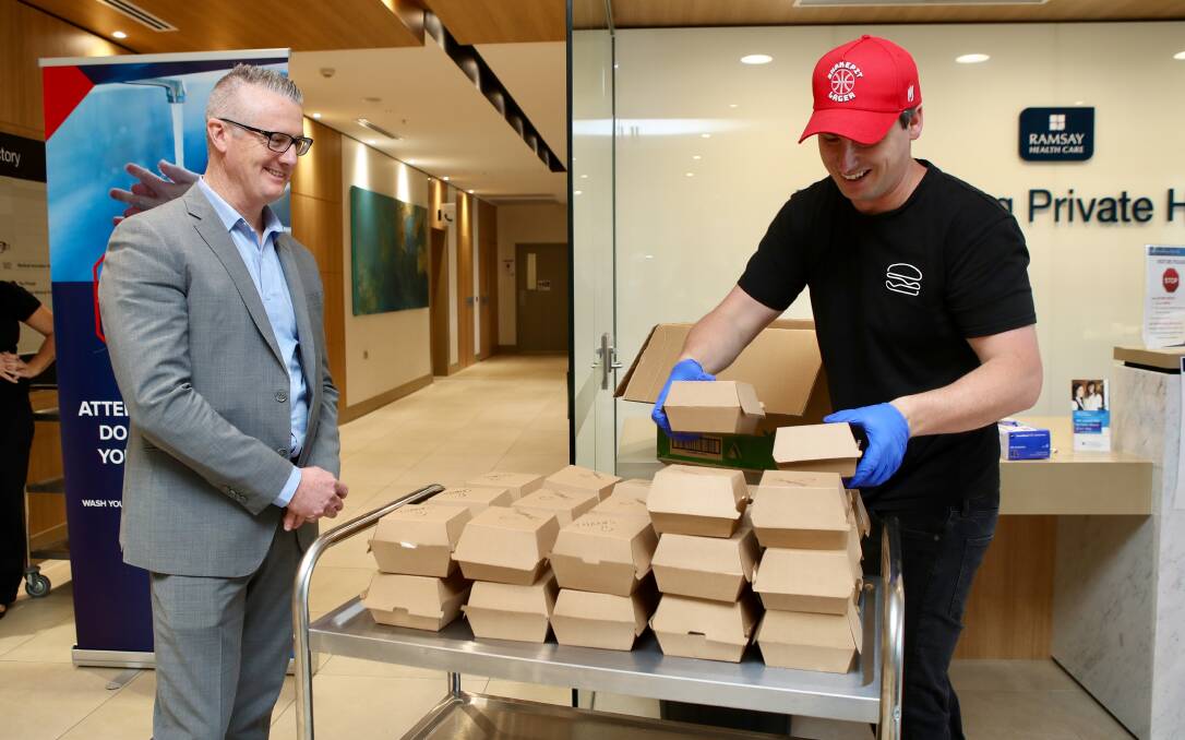 Adapting fast: Wollongong Private Hospital CEO, with Lachlan Stevens, of His Boy Elroy, who delivered lunch for 200 hospital staff on Thursday. Picture: Adam McLean. 