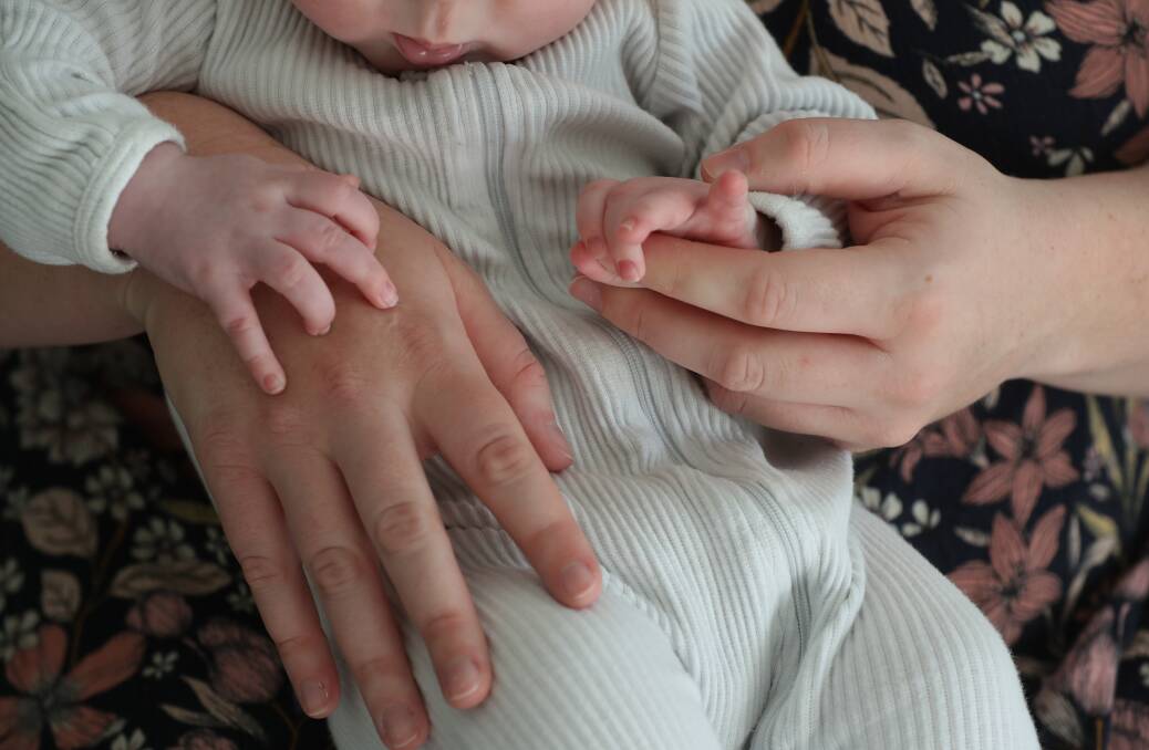 Calderwood mother Lauren, who asked not to be identified in a photo, has spoken about her two traumatic births. Her hands are pictured here with her second son Oliver. Picture by Robert Peet