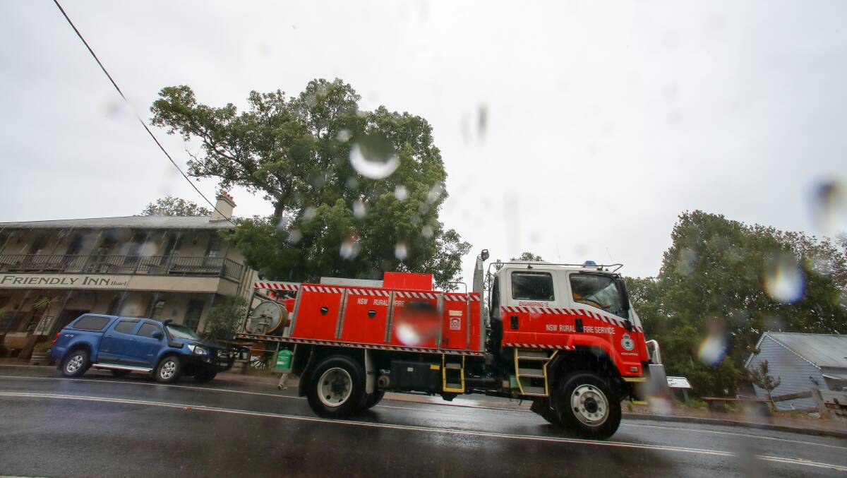 Reprieve: As rain fell in Kangaroo Valley on Monday, exhausted RFS crews used the time to have a break. While welcome, the rain was also a hindrance to any backburning as the damp ground meant controlled fires would not ignite. Picture: Adam McLean.