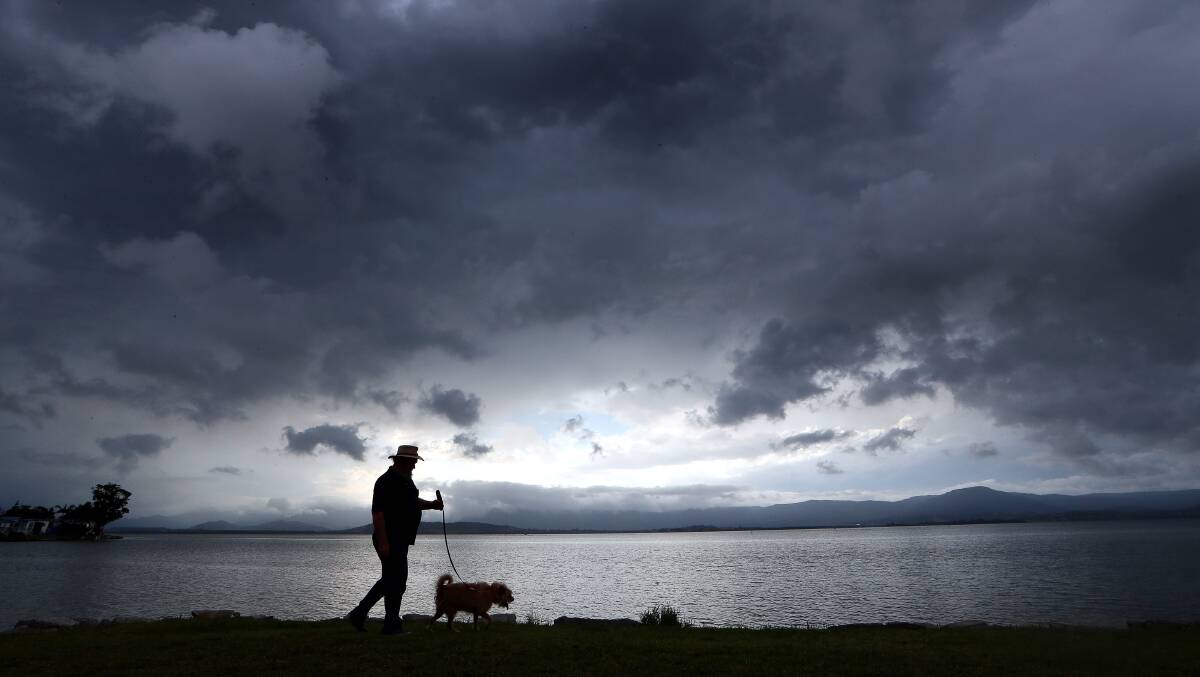 Glenn Baker with his dog Dylan walking along the waters edge at Lake Illawarra on Tuesday afternoon. Picture: Sylvia Liber.
