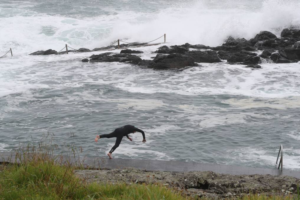 A swimmer dives into the Kiama rock pool on Tuesday, a day after a man in his 60s was washed out of the pool by a large wave. Picture by Robert Peet.