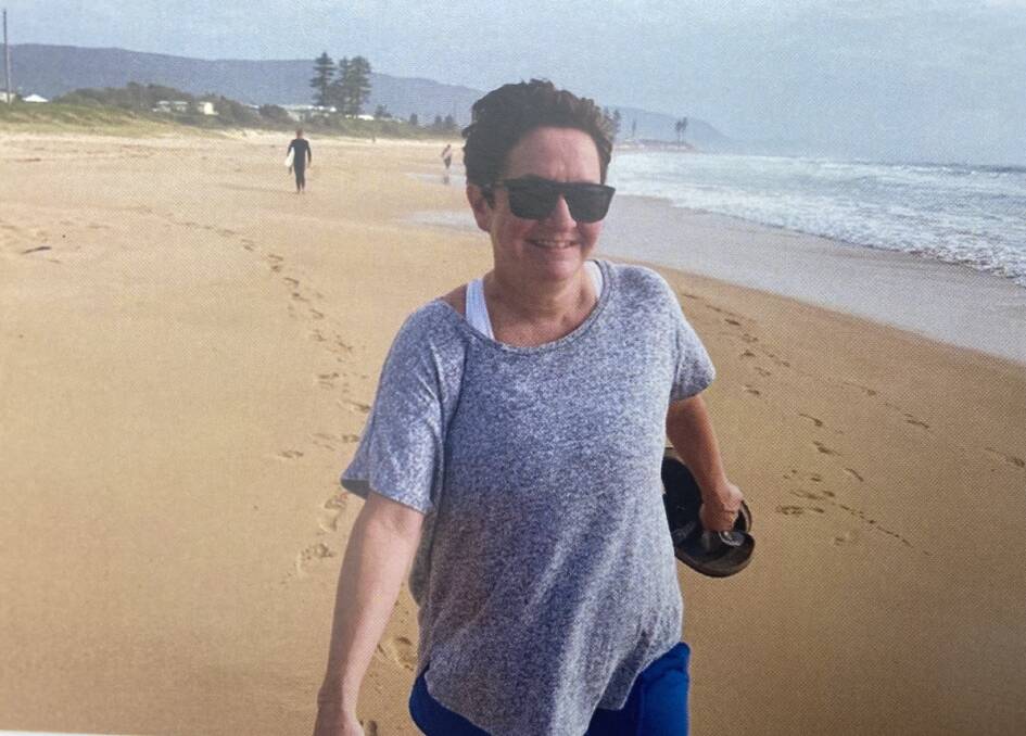 In her element: Angela O'Donnell strolls along Woonona Beach in 2019 in a candid picture taken by her family in the months before her death. Picture: Supplied