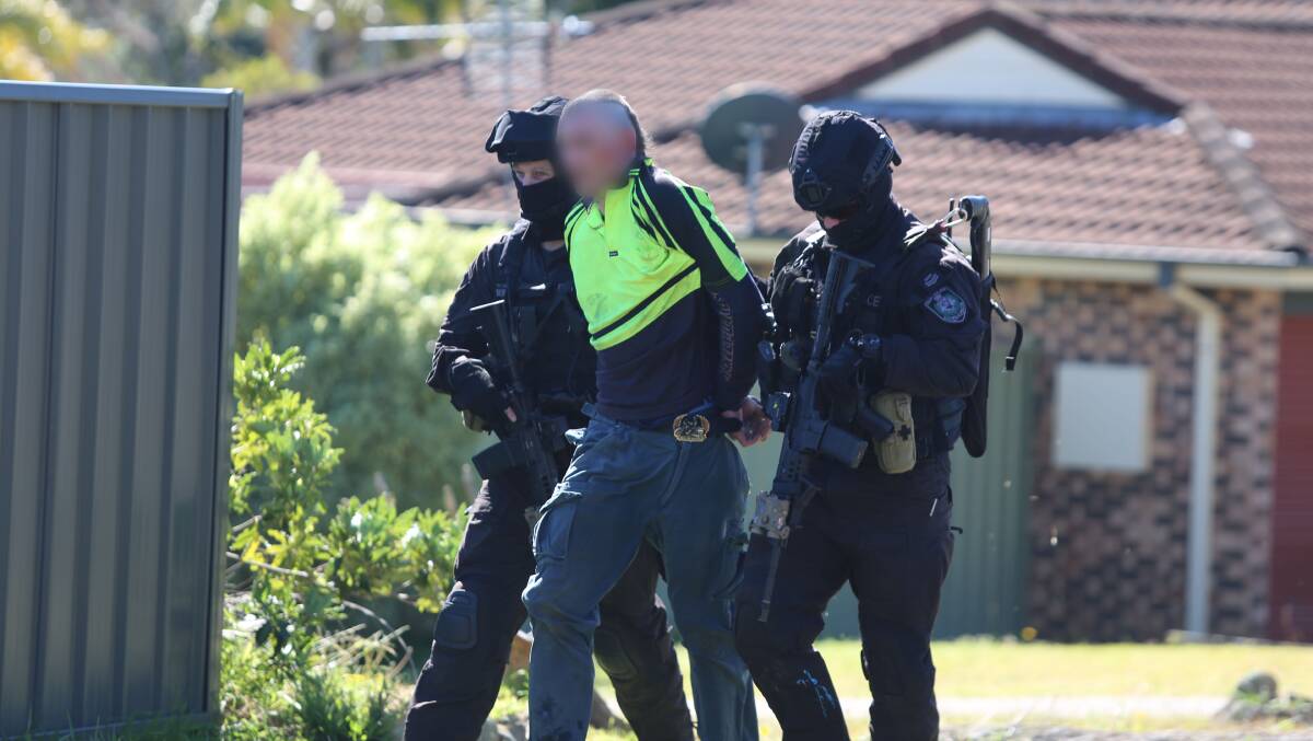 Heavily armed members of the Tactical Operations Unit (TOU) arrest Graeme Ian Young, the man accused of being the mastermind behind a North Nowra drug ring, after Thursday's raid. Photo: NSW Police Media
