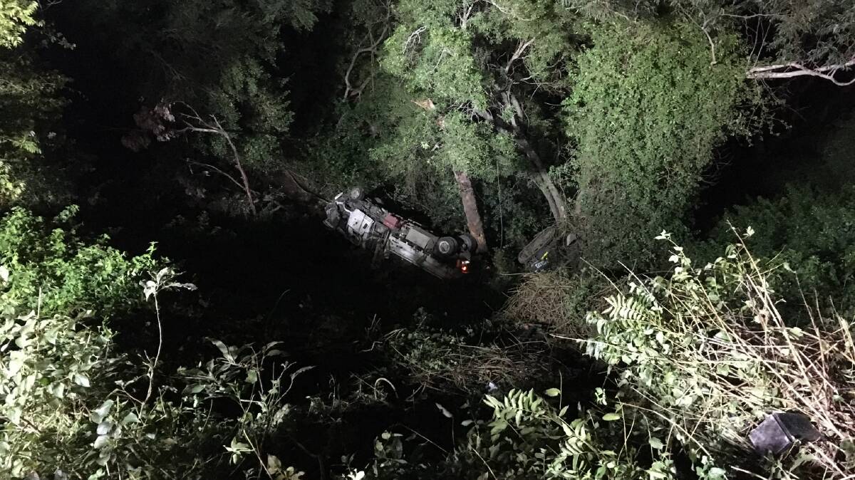 The scene emergency crews faced on Friday evening after the truck and excavator rolled 50 metres down the side of Cambewarra Mountain.