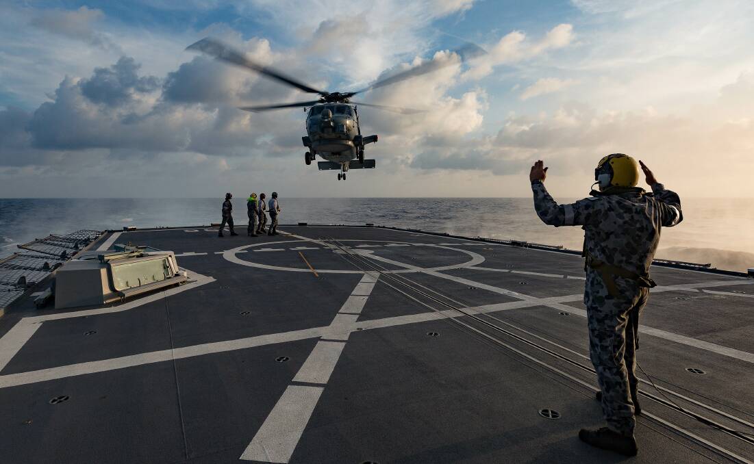 MANOEUVRE: HMAS Toowoomba's MH-60R helicopter prepares to conduct a personnel transfer at sea while en-route to South East Asia. Photo: Steven Thompson