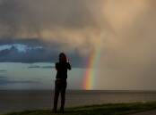 A man uses his smartphone to capture a beautiful rainbow at Barrack Point on the weekend. Picture: Sylvia Liber