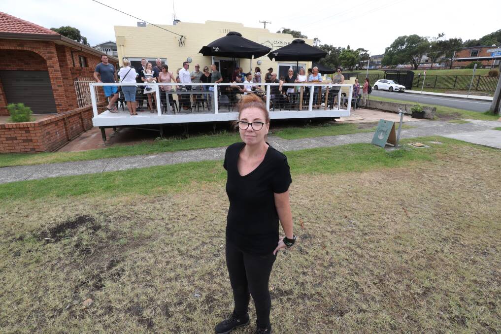 Small businesswoman Rachel Weekes outside her Port Kembla cafe, Cakes By Rach, housing dozens of customers on Tuesday who are angry over Wollongong Council's attempt to close it down. Picture by Robert Peet.