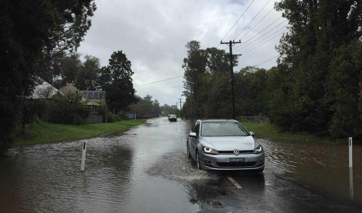 Moss Street in Terara is flooded by the rising Shoalhaven River on Monday. The SES advises motorists not to drive through floodwater. Picture: Sylvia Liber