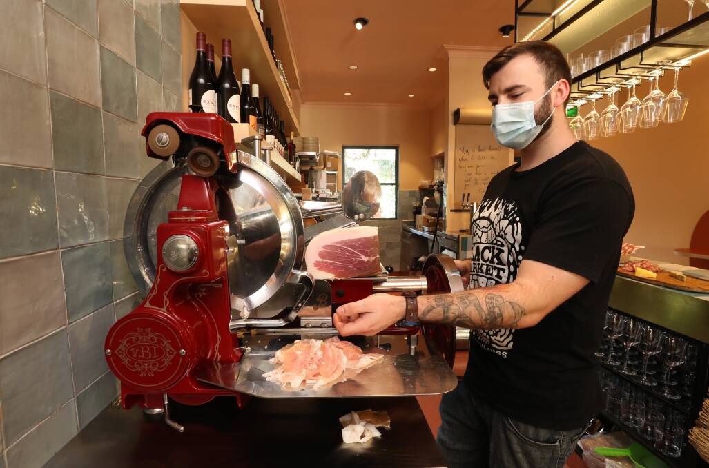 YUM YUM: Head chef of the Pickled Poet Jordan Brogan slicing prosciutto. The deli wine bare will rotate stock of cheese, wines, cured meats, preserves and more to "keep it interesting". Picture: Robert Peet
