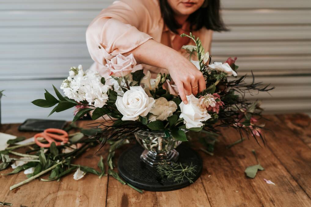 Florist Leah Mitchell works on a floral installation. Picture: The Evoke Company