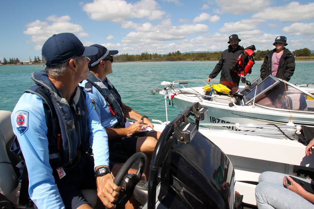 Michael Musson of NSW Maritime and Dan McAlister of Port Kembla Water Police conduct a safety check on a fishing boat on Sunday. Picture by Anna Warr.