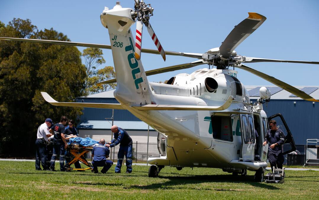 A female patient is loaded into the TOLL rescue helicopter near the Kiama sporting complex. Picture by Anna Warr.