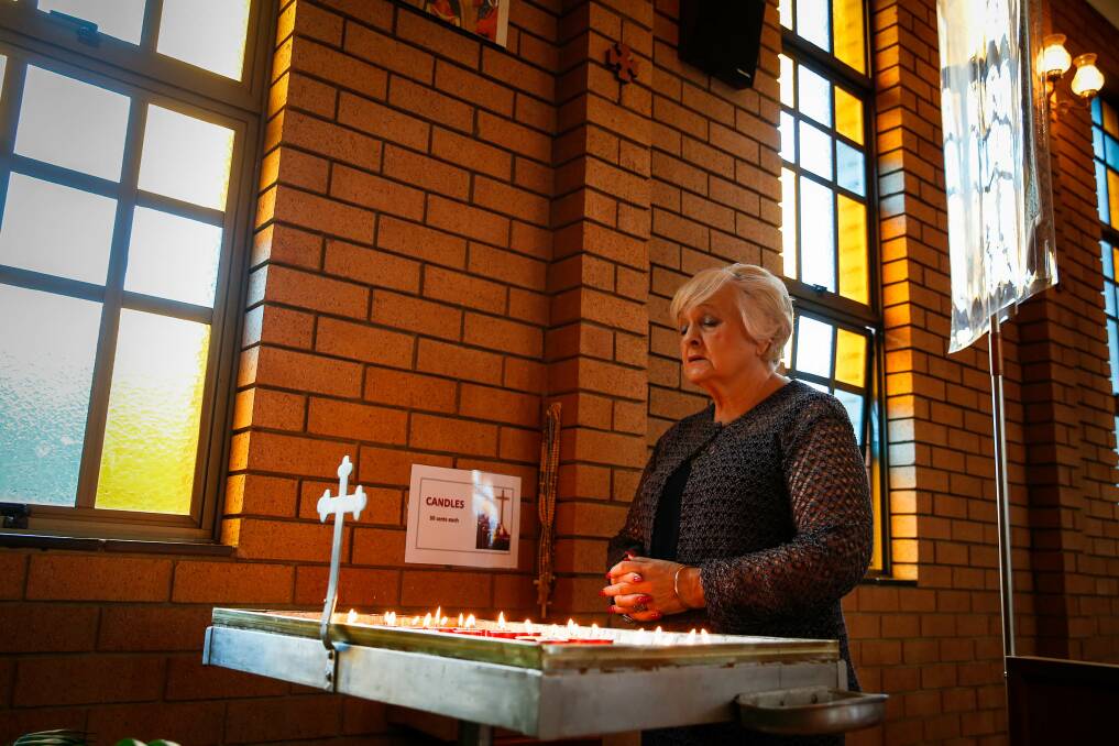 Valerie Kulyk lights and candle and prays for Ukraine. Picture: Anna Warr
