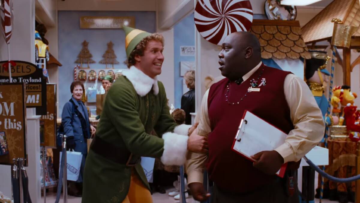 A scene from Elf, starring Will Ferrell. He plays 'Buddy', a human raised by Santa's elves, who learns about his origins and heads to New York City to meet his biological father.
