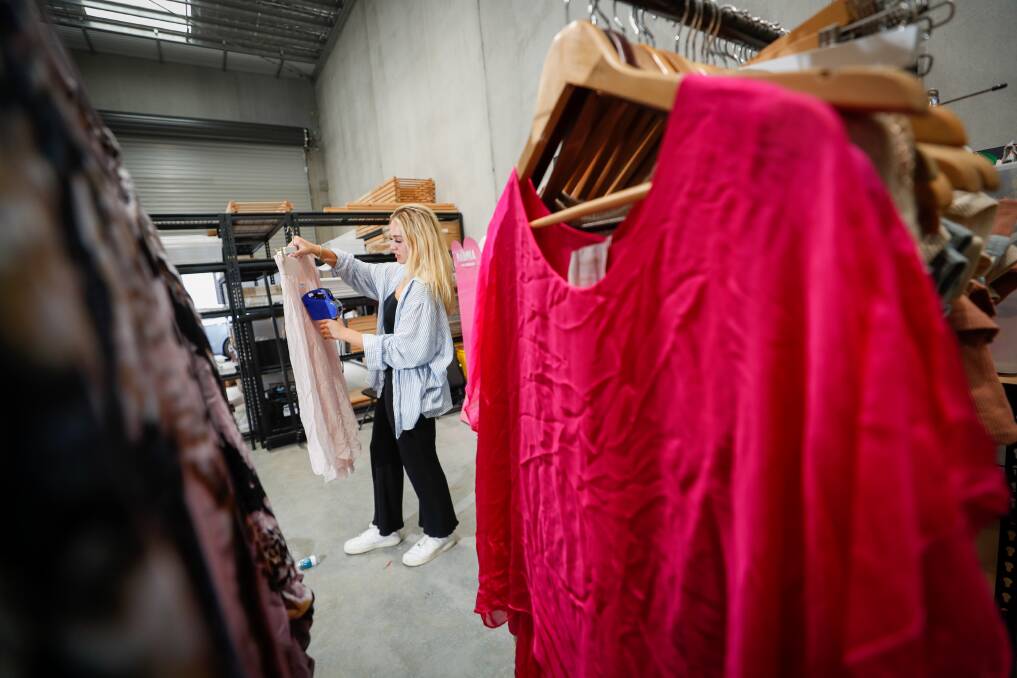 Chatterbox merchandise assistant Emily Rose pricing a skirt at the market's warehouse in Unanderra. Picture: Adam McLean