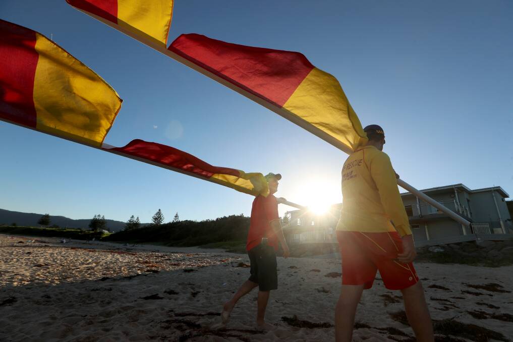There are 17 Surf Life Saving Clubs Illawarra's anthony turner (red top) and Alex Lockhart (Yellow top) packing up red and yellow flags to indicate end of surf lifesaving season - which officially finished on sunday.. Picture: Sylvia Liber