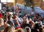 Flashback to the 2023 Illawarra Folk Festival, a band performs to a packed house above the pavilion at Bulli Showground. Picture by Anna Warr