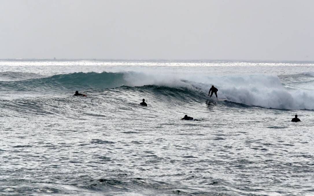 BUMPY CONDITIONS: Surfers brave it at Shellharbour on Sunday morning. Picture: Sylvia Liber