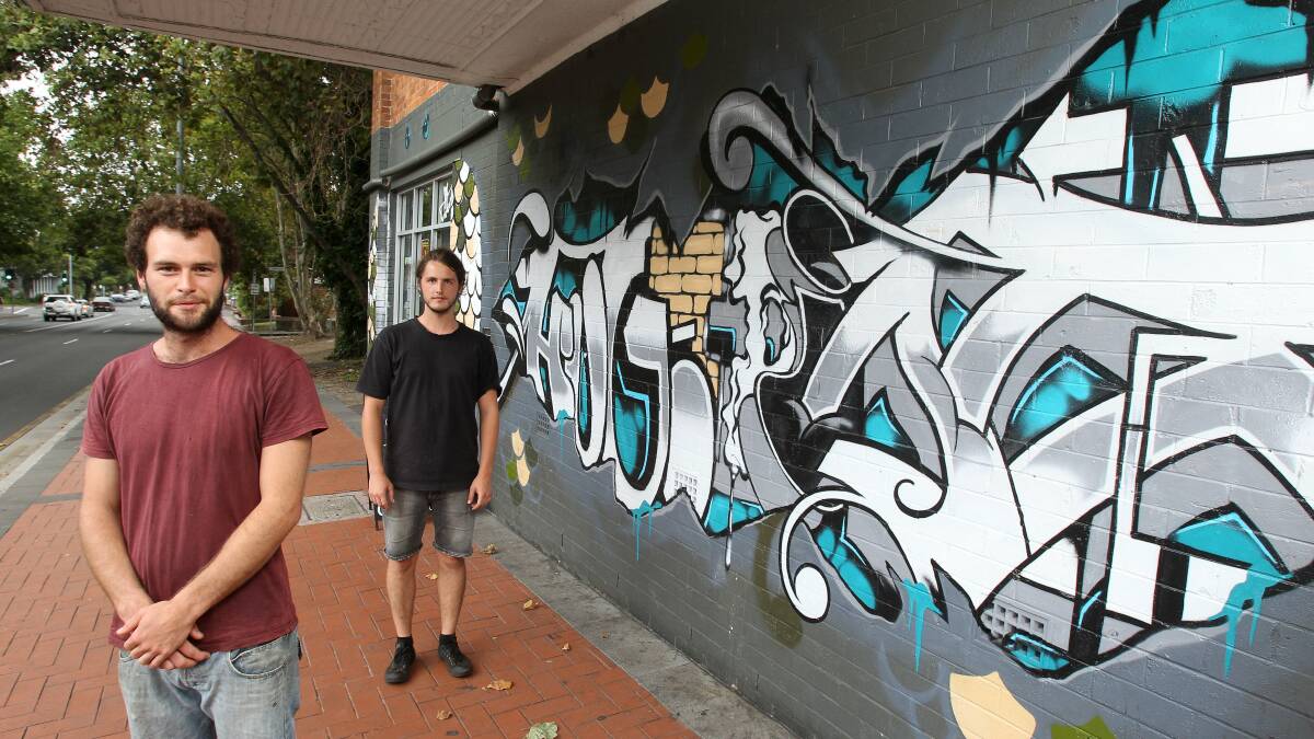 REWIND to 2012: Ballun Jones and Adam Smith from Yours and Owls on Kembla St Wollongong with the wall they painted but the landlord has asked them to paint over or pay their landlord $1100 for the paint job. Picture: Kirk Gilmore