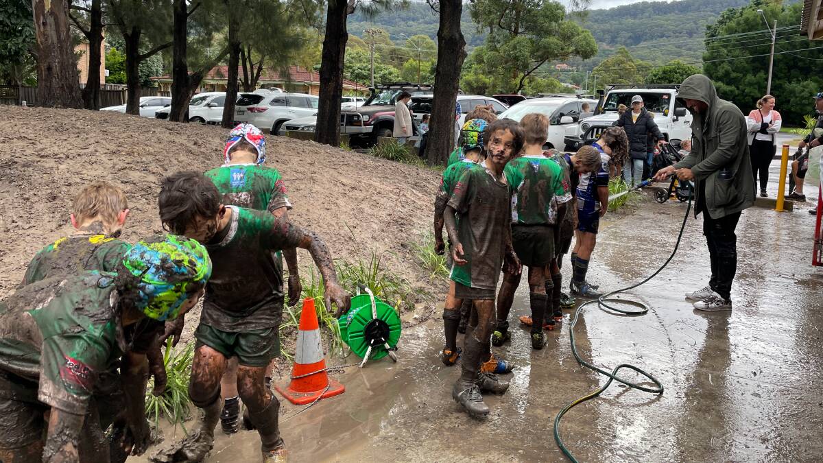 The Woonona Bulli Bushrangers Under 9 team get hosed down after a very muddy match. Photo: Anna Warr