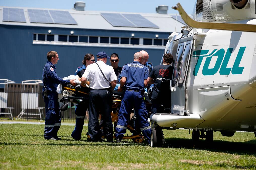 A female patient is loaded into the TOLL rescue helicopter near the Kiama sporting complex. Picture by Anna Warr.