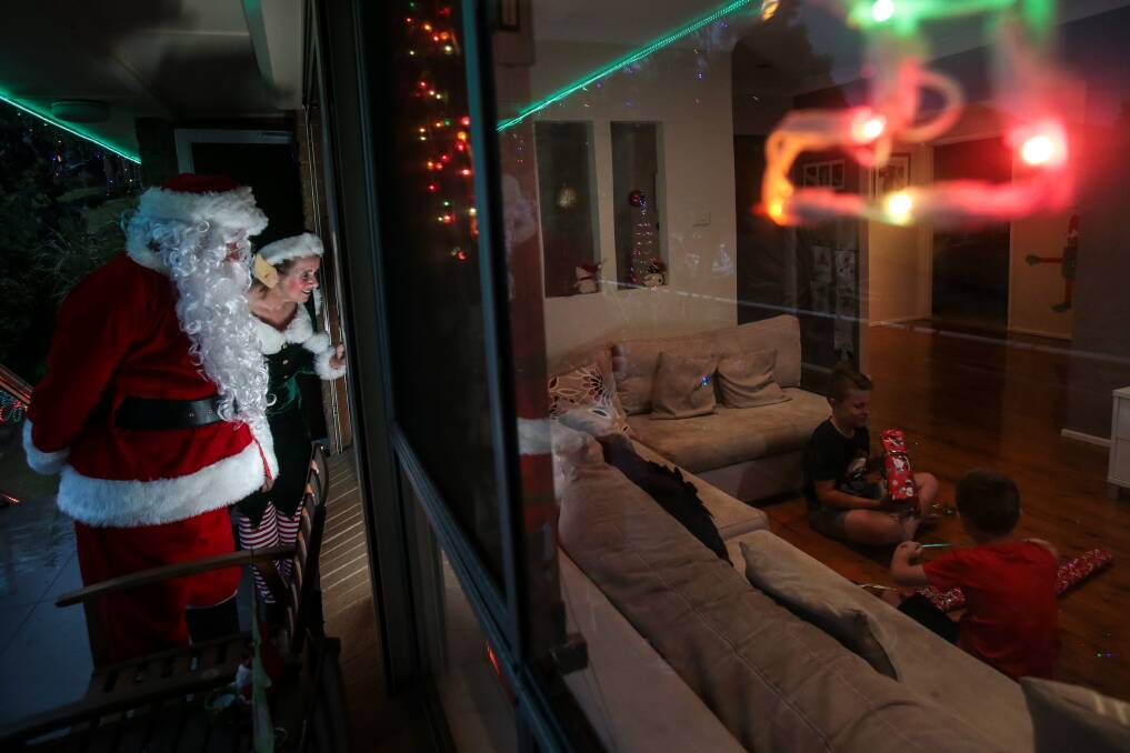 SANTA'S HELPER: Elf Juliet assists Santa to check they can easily deliver presents to Bailey and Cooper Radic's house on Christmas Eve. Picture: Adam McLean