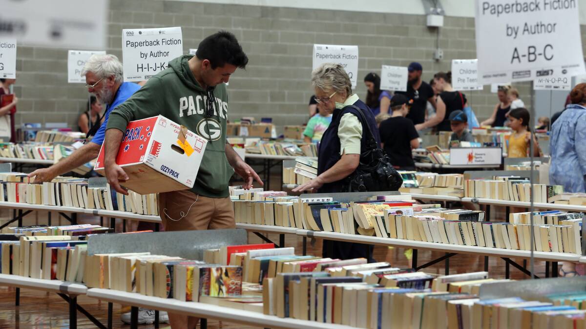 People searching through the thousands of books available at the Lifeline Big Book Fair  at the Illawarra Sports Stadium Berkeley on Saturday. Picture: Robert Peet