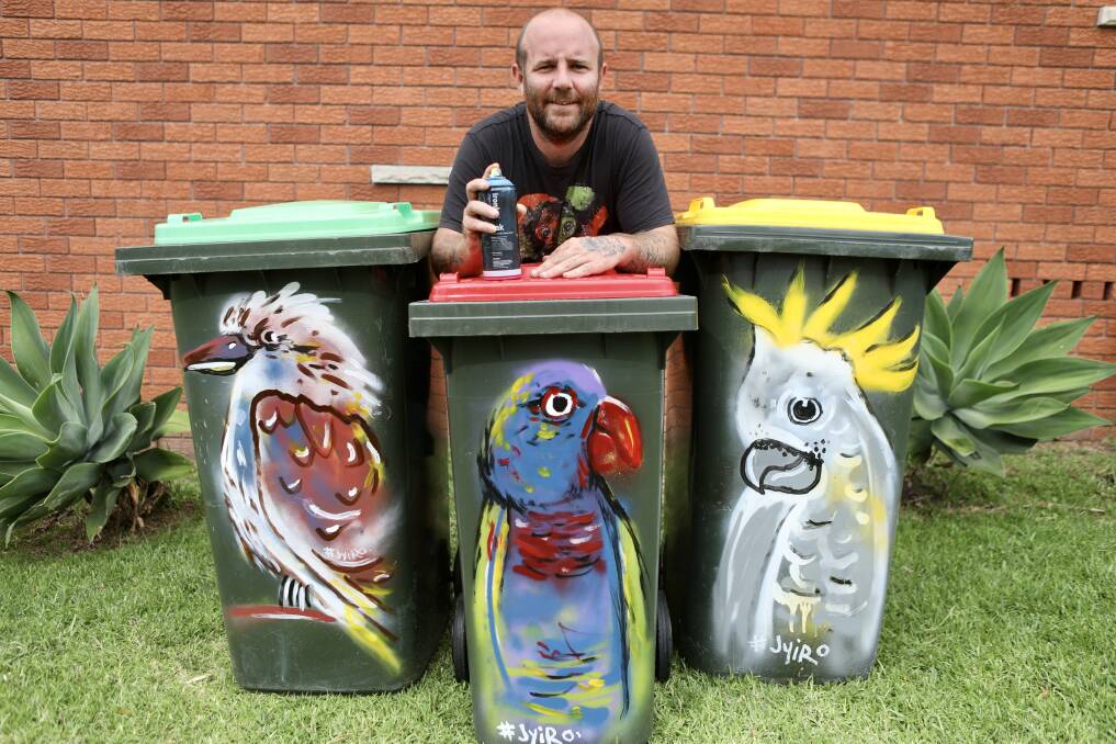 STREET ART: Jyi 'Jyiro' Westaway with some of the wheelie bin art hes been commissioned to do. Picture: Adam McLean.