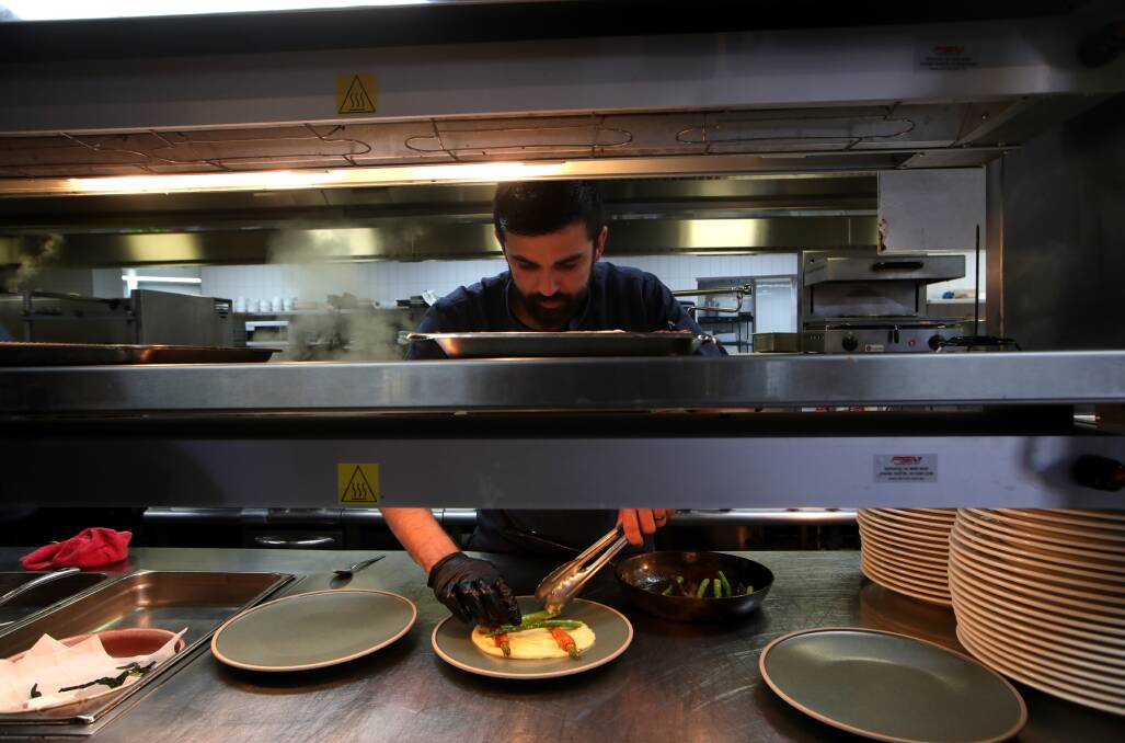 Sous chef Shaun Lawson at The Mill inside Dapto Leagues Club, plating up their signature dish. Picture: Sylvia Liber