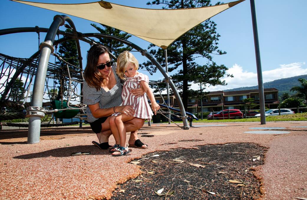 Mum Sasha Sacconi and daughter Olivia Wood, four, inspect one of the larger craters that could be found at the park on Friday. Picture: Anna Warr
