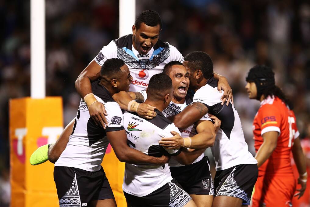 JUBILANT: Jimmy Storer is swamped by teammates after scoring a try in Fiji's epic clash with Tonga on Saturday. Picture: Getty Images