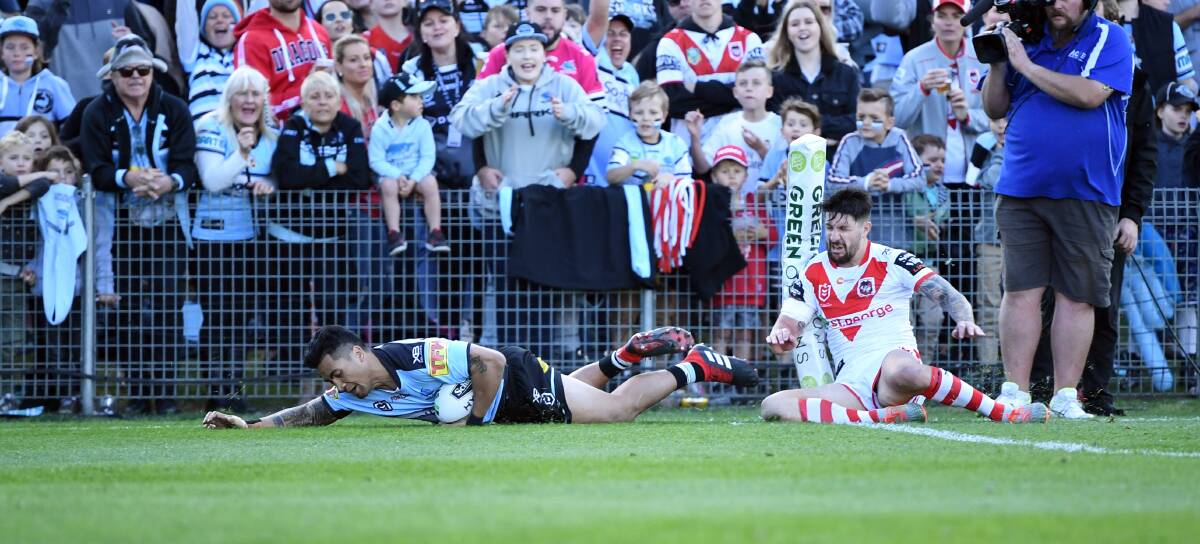 OUCH: Sosaia Feki crosses for the Sharks against the Dragons on Sunday. Picture: NRL Photos