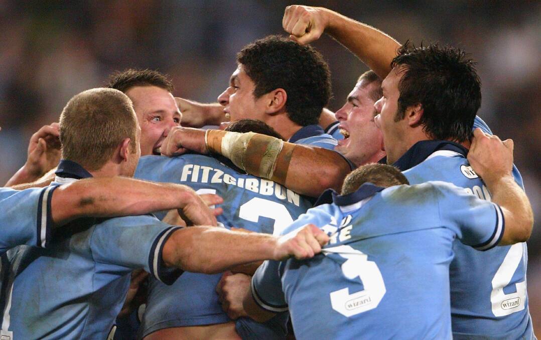 HUGE MOMENT: Shaun Timmins is mobbed after kicking the winning field goal in game one of the 2004 State of Origin series. Picture: Getty Images