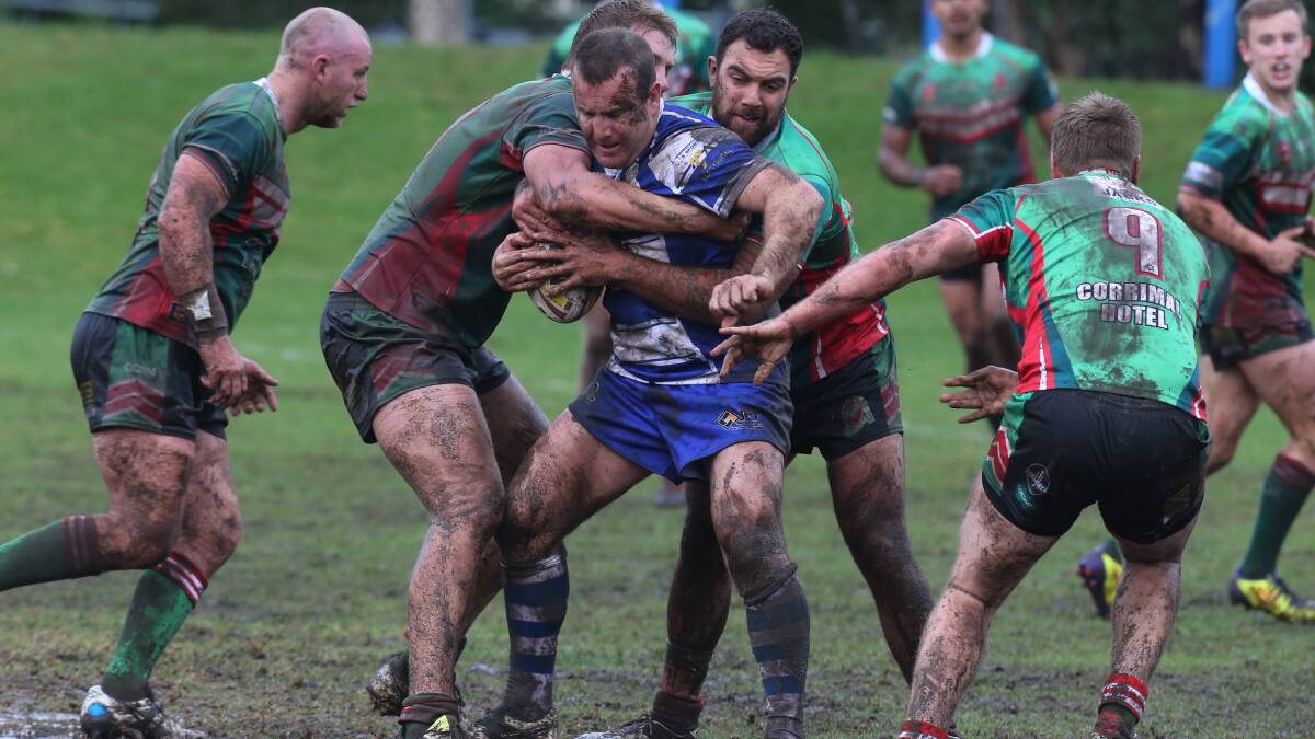 TOUGH DAY: Thirroul forward Aaron Beath takes on the Corrimal defence in rough conditions at Gibson Park. Picture: Robert Peet
