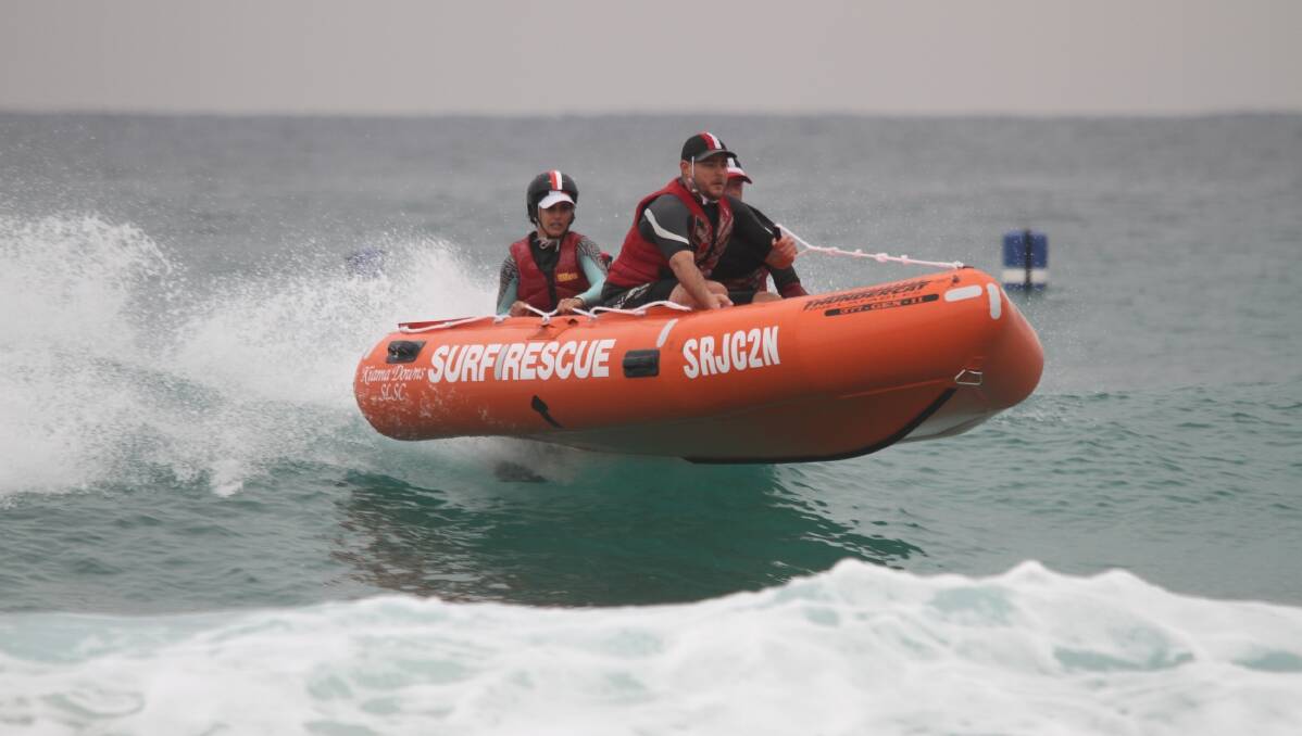Riding high: The Kiama Downs inflatable rescue crew head to shore in the final round last weekend. They won their sixth straight premiership title. Picture: Alan Freeman